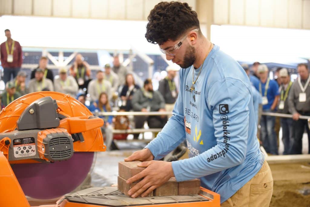 Young man using wet saw cutting blocks