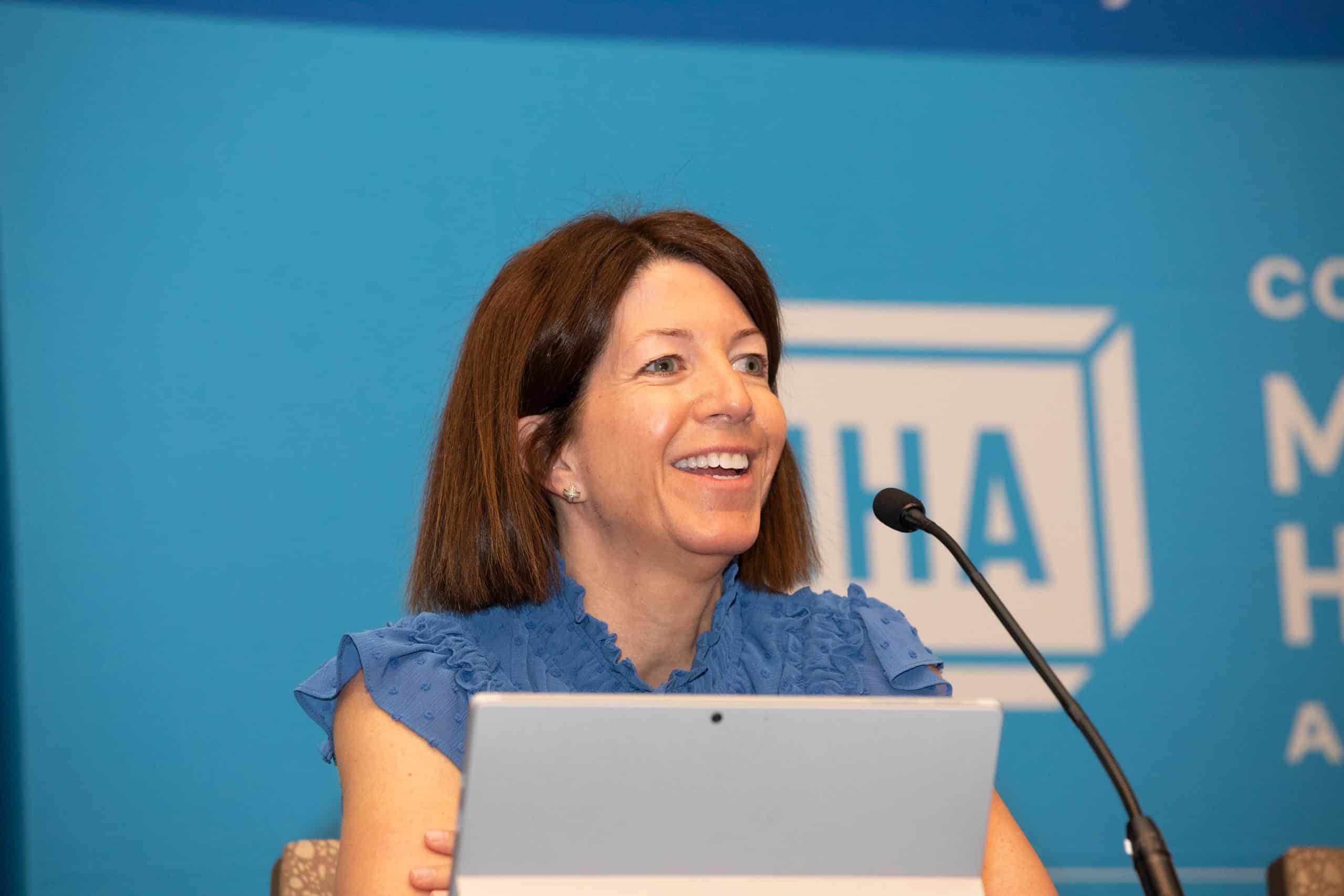 Woman member speaking at event